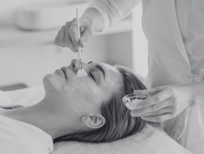 Woman laying with eyes closed while getting a facial